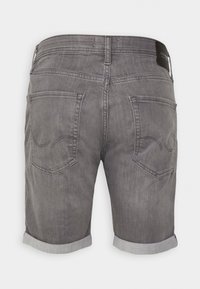 Szare szorty z denimu z podwiniętymi mankietami, wyposażone w dwie tylne kieszenie i subtelne szczegóły szwów. Materiał ma gładką, lekko fakturowaną powierzchnię.