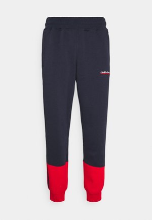 Navy blue sweatpants with red cuffs, elastic waistband, side pockets, and small white and red Adidas logo on left thigh.