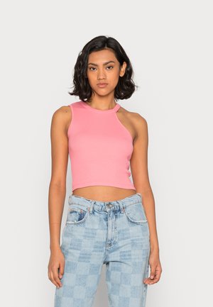 Rosa ribbet crop topp med høy hals og uten ermer, kombinert med lyseblå rutete jeans. Glatt tekstur, uformell stil.
