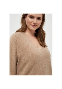 Beiger, gemütlicher Strickpullover mit V-Ausschnitt; verfügt über eine leicht strukturierte Oberfläche und einen lässigen Schnitt. Einfacher und vielseitiger Stil.