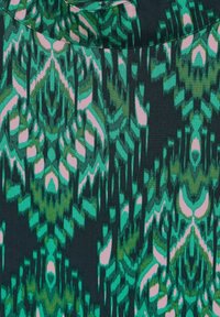 Grön och rosa mönstrad tyger med intrikata zigzag- och bladmönster på en mörk bakgrund. Mjuk textur med ett flödande utseende.