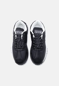 Μαύρα αθλητικά παπούτσια με υφή από δέρμα και δίχτυ στο επάνω μέρος, λευκό εσωτερικό, μαύρα και λευκά κορδόνια και λογότυπο στη γλώσσα. Λαστιχένια σόλα.