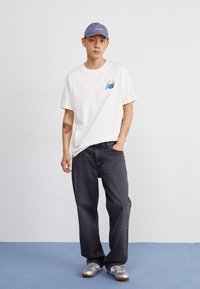 New Balance ATHLETICS RELAXED GOLF CARTOON - Apdrukāts T-krekls - sea salt