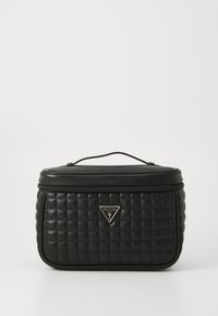 Borsa cosmetica nera trapuntata con una forma strutturata, chiusura con cerniera, manico superiore e un accento in metallo triangolare. Texture liscia, materiale sintetico.