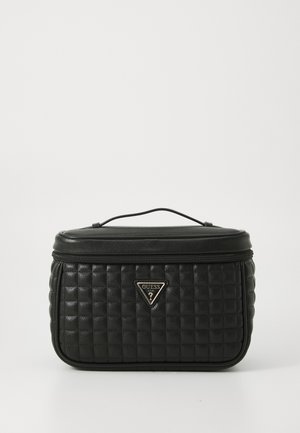Borsa cosmetica nera trapuntata con una forma strutturata, chiusura con cerniera, manico superiore e un accento in metallo triangolare. Texture liscia, materiale sintetico.