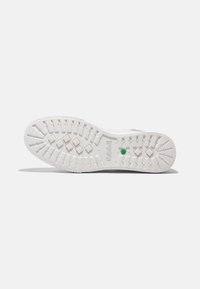 White sneaker sole with textured rubber for traction, featuring a green accent and patterns of diamond shapes and horizontal grooves.