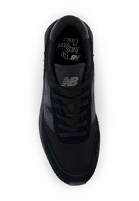 Fekete New Balance sneaker hálós és velúr textúrákkal, fekete fűzőkkel, és a talpbetétre nyomtatva: "Az Értelmes Választás".