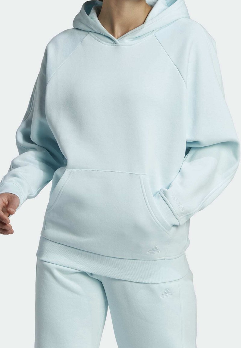 Sweat à capuche bleu clair en tissu doux, avec une poche kangourou, des poignets côtelés et une capuche ajustable avec cordon de serrage.