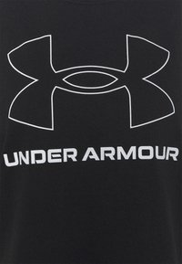Svart t-shirt i bomull med en stor vit Under Armour-logotyp och text nedanför i fet stil. Slät textur, standard crew neck-design.