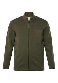 Chaqueta verde oliva con cremallera, cuello alto, textura acanalada, mangas largas y un bolsillo en el pecho. Presenta detalles de cremallera metálica.