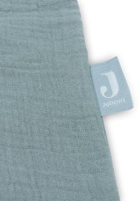 Zachte, lichtblauwe mousseline stof met een licht gestructureerd oppervlak, met een klein etiket waarop "Jollein" in het wit staat.