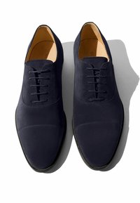 Scarpe stringate in camoscio blu navy con finitura liscia, punta arrotondata e dettagli cuciti sottili sulla parte superiore e suola scura.