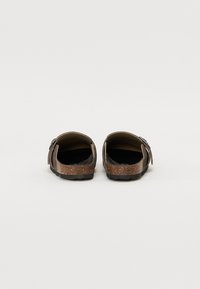 Bruine instapsandalen met kurken voetbed, rubberen zool en twee verstelbare banden. Gladde textuur met een matte afwerking.