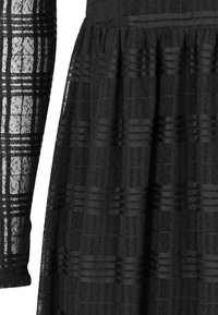Czarna sukienka z textured wzorem, z tkaną siatką na koronkach i rękawach oraz plisowaną spódnicą.
