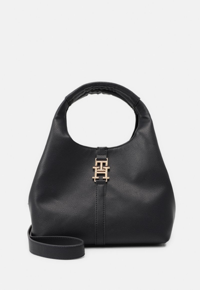 Sac à main en cuir noir avec poignée arrondie, fermoir double T doré et bandoulière amovible sur fond uni.
