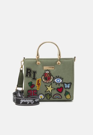Torebka w oliwkowym kolorze z złotymi uchwytami, czarnym paskiem oraz kolorowymi naszywkami przedstawiającymi oko, gwiazdę, serce, motyla, tęczę, ananasa i błyskawicę.