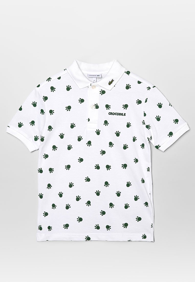 Biała koszulka polo z zielonym nadrukiem w wzór łap krokodyla, krótki rękaw i kołnierzyk. Posiada tekst "CROCODILE" oraz zapięcie na guziki. Materiał bawełniany.