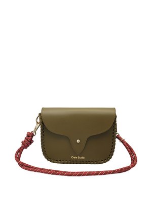 Sac bandoulière en cuir vert olive avec rabat festonné, bouton doré, bords tressés et bandoulière amovible en corde rouge avec accents blancs.
