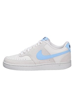 Baskets basses blanches avec un swoosh Nike bleu clair et une languette au talon, mélange de suède et de cuir, lacets blancs et bout perforé.