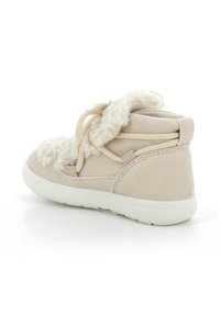 Stivaletti alla caviglia in suede beige con colletto bianco peloso, design con lacci, suola in gomma texturizzata e dettagli cuciti sui lati.