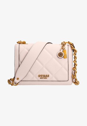 Sac bandoulière matelassé rose clair avec bandoulière chaîne dorée, logo GUESS et breloques dorées décoratives dans le coin avant.