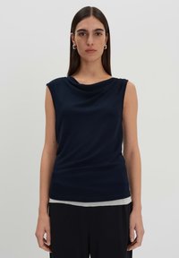 Top senza maniche blu navy con scollatura drappeggiata, realizzato in tessuto morbido. Presenta una silhouette aderente e dettagli a coste sottili nell'orlo.