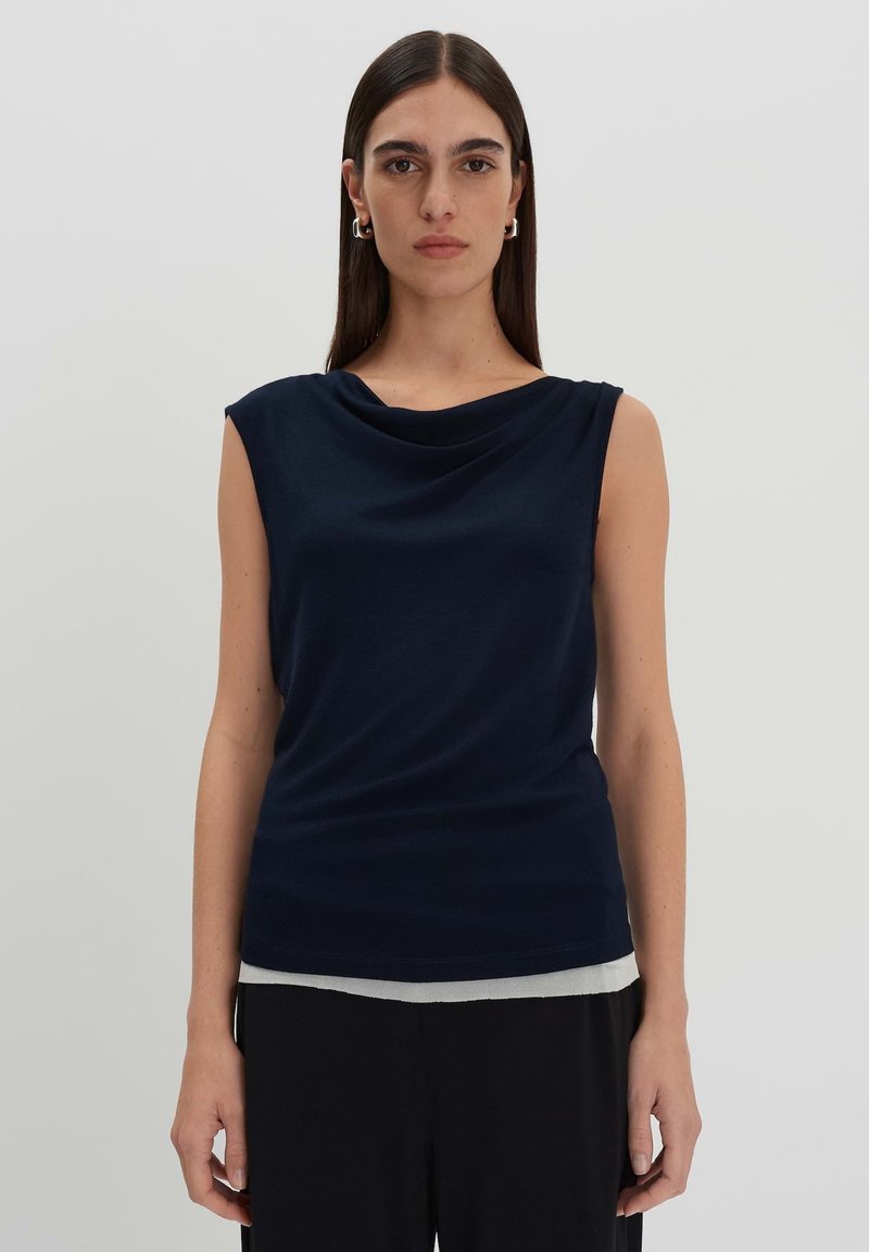 Top senza maniche blu navy con scollatura drappeggiata, realizzato in tessuto morbido. Presenta una silhouette aderente e dettagli a coste sottili nell'orlo.