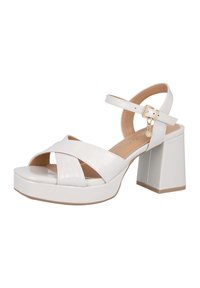Sandalias de tacón alto blancas con un acabado brillante, con correas entrecruzadas, hebilla en el tobillo y un tacón cuadrado grueso.
