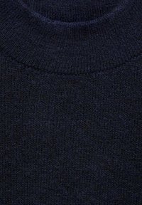 Pull en maille bleu marine avec un col rond. Tissu texturé présentant un motif côtelé autour du col et de légères variations de ton.