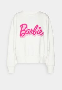 Vit sweatshirt med rund halsringning, med en fluffig rosa "Barbie"-logotyp i kursiv som går över bröstet. Mjukt tyg med lös passform och ribbade muddar.