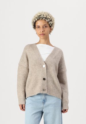 Cardigan en tricot beige à manches longues, décolleté en V, tissu texturé et fermeture à cinq boutons avec un mélange de boutons ronds et à motifs.