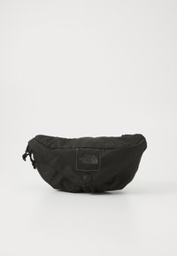 Schwarze Beutel Tasche mit rundem Design. Hergestellt aus Nylonstoff, mit einem Logo-Patch, Kordelzugverschluss und einem frontalen Knopfakzent.