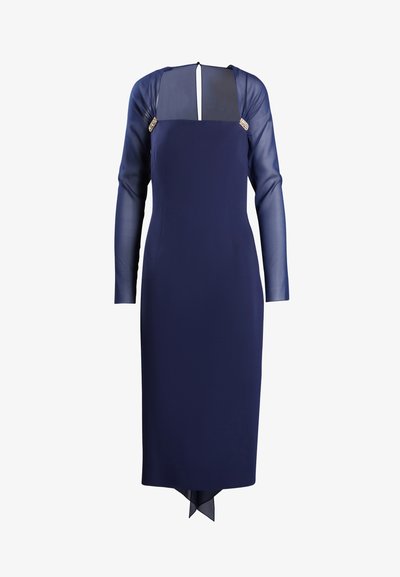 Jūrinė suknelė su ilgomis permatomomis rankovėmis ir kvadratine iškirpte. Yra dekoratyvi aparatūra ant pečių ir vidutinio ilgio iki pusės blauzdų su užpakaline suplėšimu.