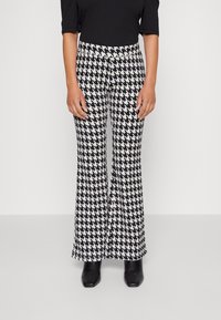 Svart och vit houndstooth-mönstrade utsvängda byxor med en slät textur, som har hög midja och en åtsittande silhuett upptill.