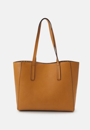 Sac cabas en cuir marron avec deux longues poignées et une surface lisse légèrement texturée, présenté sur un fond clair uni.