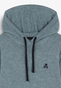 Hanorac gri deschis cu buzunar kangaroo, șnururi negre și un mic logo întunecat cu craniu și oase încrucișate pe piept. Material moale și texturat.