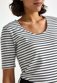 Stripet T-shirt med korte ærmer i hvid og sort, med en klassisk scoop neckline og blødt stof med en glat tekstur.