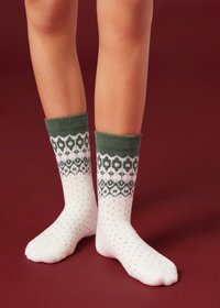 Calzini lavorati a maglia con polsino verde decorato e corpo bianco con motivo a pois. Texture morbida, adatta per calore e comfort.