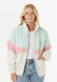 Giacca in corduroy verde menta, rosa e crema con colletto alto, bottoni a pressione e polsini elasticizzati. Presenta un design geometrico a blocchi di colore.