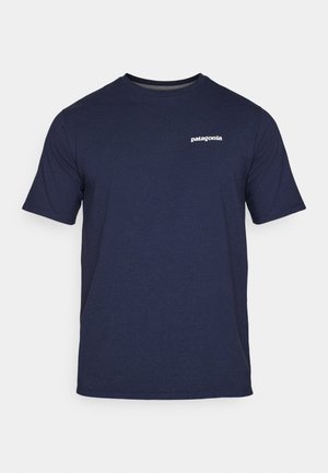 T-shirt in cotone blu navy con maniche corte, colletto a giro e logo "patagonia" bianco sul lato sinistro del petto. Tessuto morbido, vestibilità classica.