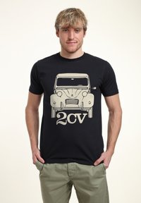 Černé tričko s béžovou ilustrací vintage auta, zaobleného tvaru, s výraznými světlomety a textem "2CV" níže.