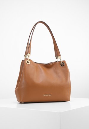 Bruine leren Michael Kors handtas met dubbele schouderbanden, hardware in goudkleur en een getextureerde afwerking, geplaatst op een wit oppervlak.