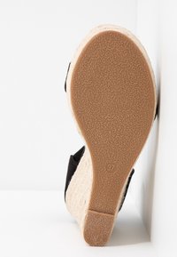 Sandale espadrille noire avec un talon en jute et une semelle en caoutchouc texturé, taille 37, dotée d'un dos ouvert et d'une sangle à la cheville.