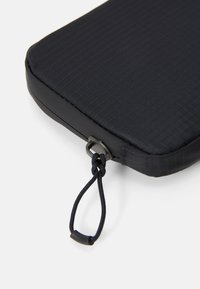 Black rectangular pouch made of textured fabric, featuring a looped drawstring and metal hardware for secure closure.