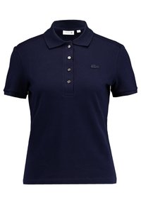 Polo en bleu marine en tissu texturé, avec un col classique, une patte de boutonnage à cinq boutons et un logo brodé sur la poitrine.