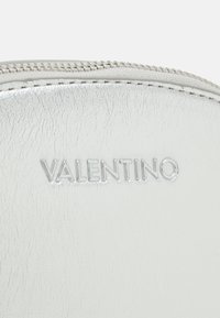 Silverfärgad läderpouch med struktur, utrustad med en dragkedja upptill och präglad "VALENTINO"-logotyp. Slät yta med synlig sömnad och glans.