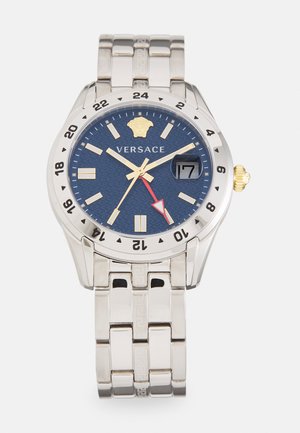 Montre en acier inoxydable argenté avec un cadran texturé bleu, des accents dorés, une aiguille des secondes rouge, un affichage de la date et un design de bracelet maillons.