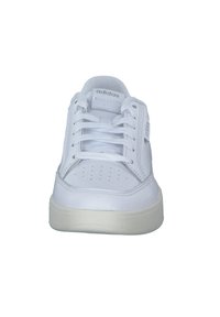 Baskets blanches en cuir avec une texture lisse, design à lacets, bout perforé pour la respirabilité et semelle en caoutchouc. Présente le logo de la marque sur le côté.