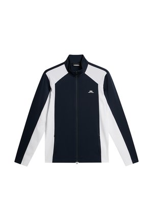 Navy and white zip-up jacket featuring a high collar, two side pockets, and a logo on the chest. Made from smooth, stretchy fabric.