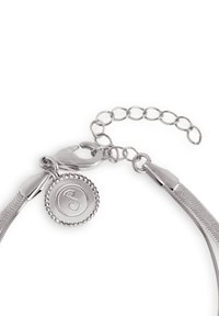 Bracciale argentato con design a rete flessibile, chiusura a scatto e un charm rotondo con logo 'S', dettagliato con bordi perlati.